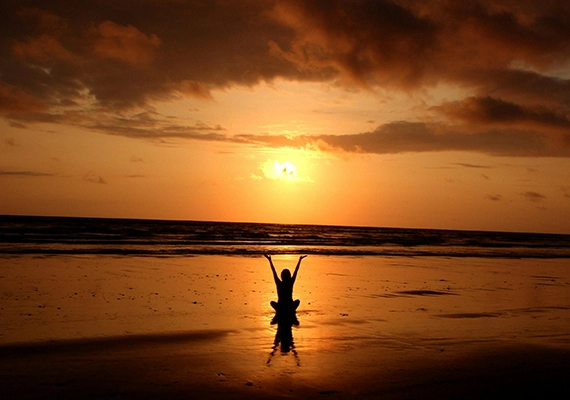 Sunset with woman doing yoga pose.