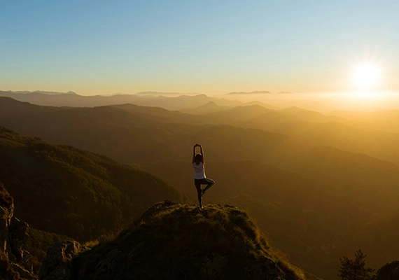 Sunset with woman doing yoga pose.