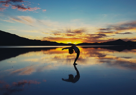Sunset with woman doing yoga pose.