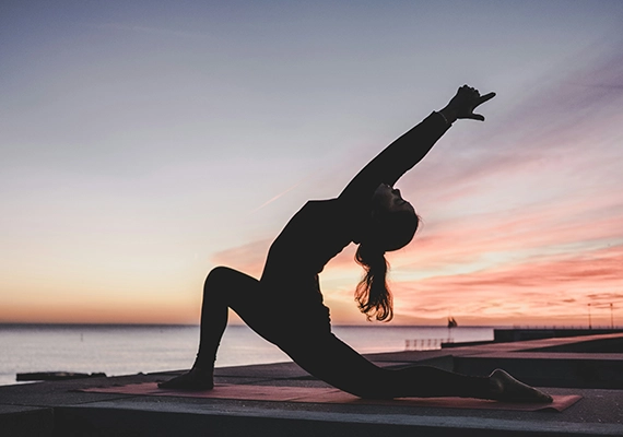 Sunset with woman doing yoga pose.